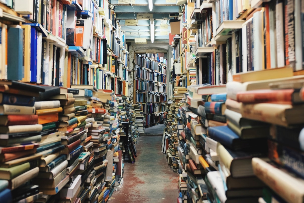Bookshop stacked high with books on both sides of a narrow aisle